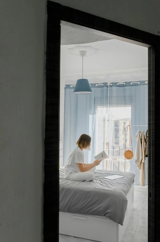 Kobieta czyta książkę w jasnej sypialni