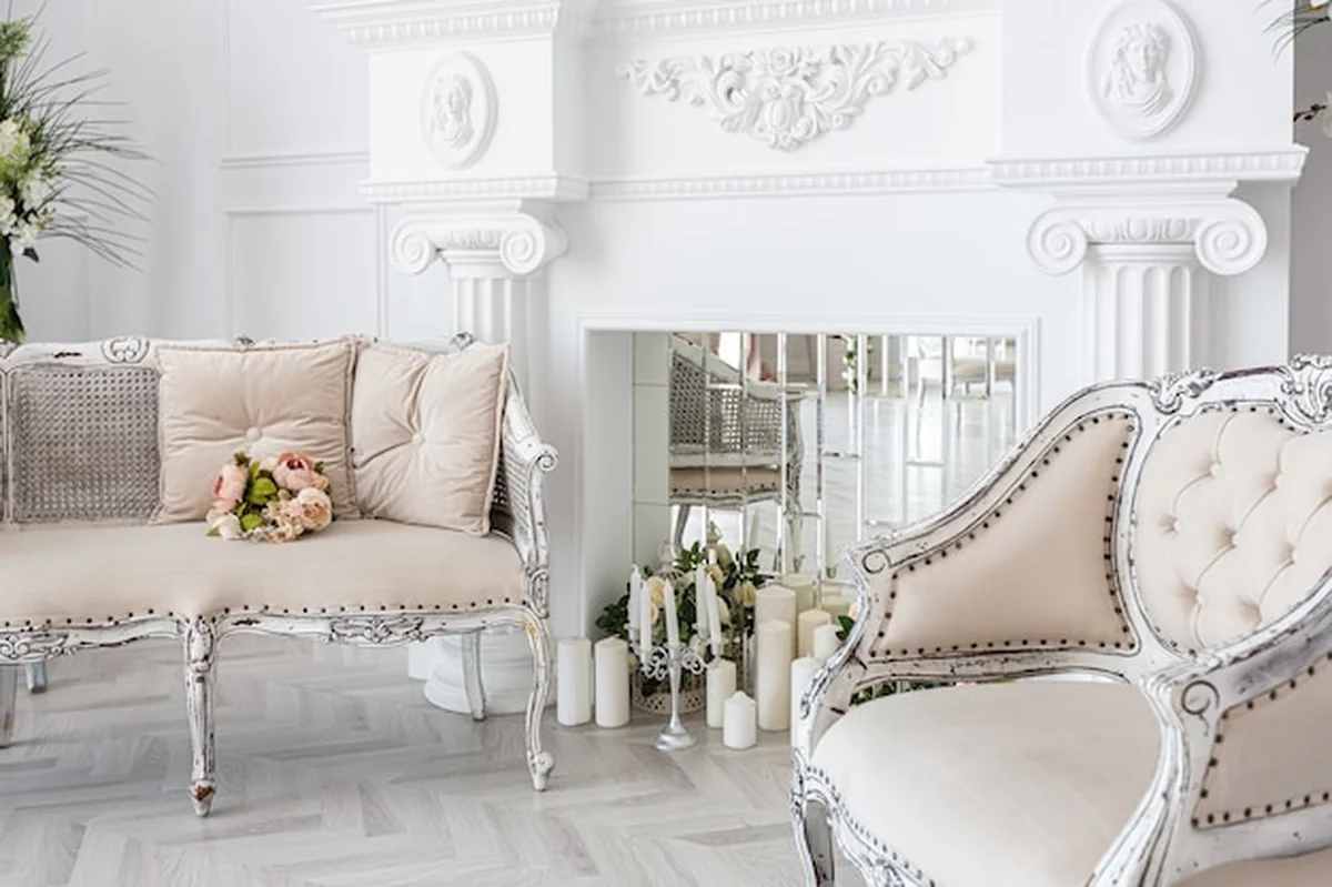 Luksusowy salon z eleganckimi meblami, dużym oknem, roślinami, sztukaterią i kominkiem