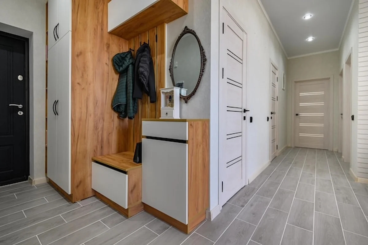 Małe wnętrze korytarza wejściowego z wieszakiem do butów i lustrem