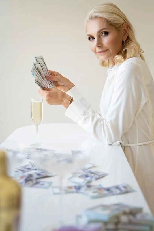 Portret bogatej kobiety z blondynką i banknotami